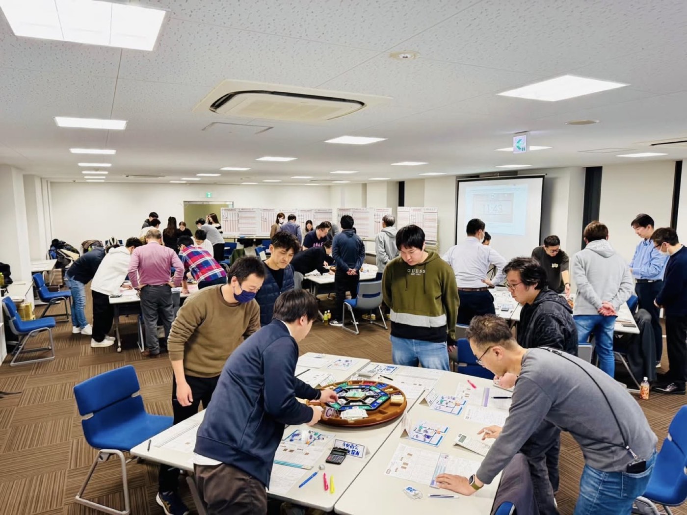MG研修でゲーム盤を囲み夢中で学ぶ参加者たち